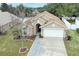 Tan house with a white garage door and a landscaped yard at 30129 Pga Dr, Sorrento, FL 32776