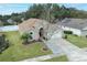 One-story home with brown roof, landscaping, and a paved driveway at 30129 Pga Dr, Sorrento, FL 32776