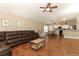 Spacious living room featuring a leather sectional sofa and wood-look floors at 30129 Pga Dr, Sorrento, FL 32776