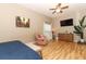 Bright main bedroom featuring a large TV, comfortable seating, and hardwood floors at 30129 Pga Dr, Sorrento, FL 32776