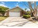 Front view of a ranch home with a two-car garage and driveway at 3131 Ash Park Loop, Winter Park, FL 32792