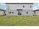 View of the backyard featuring grass and the rear elevation of the house with a sliding glass door at 3801 Giorgio Dr, Winter Haven, FL 33884