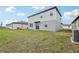 Backyard featuring grass and the rear elevation of the house, along with an air conditioning condenser at 3801 Giorgio Dr, Winter Haven, FL 33884