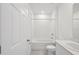 Bathroom with a shower-tub combination, white cabinets, white tiles, and white walls at 3801 Giorgio Dr, Winter Haven, FL 33884