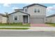 Charming two-story home with a brick driveway, a gray exterior, and a light blue front door at 3801 Giorgio Dr, Winter Haven, FL 33884