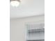 A flush mount ceiling light provides soft illumination, complemented by window blinds and a bright white ceiling at 3833 Giorgio Dr, Winter Haven, FL 33884