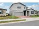 Side view of a modern two-story home with a brick driveway and well-maintained lawn at 3833 Giorgio Dr, Winter Haven, FL 33884