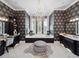 An elegant bathroom with patterned wallpaper features a soaking tub, custom cabinetry, and a luxurious chandelier at 4089 Isabella Cir, Windermere, FL 34786