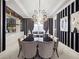 Formal dining room with a long black table, elegant chairs, striped wallpaper, and a decorative light fixture at 4089 Isabella Cir, Windermere, FL 34786