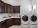 Well-organized laundry room with dark wood cabinets, white countertops, and modern washer and dryer at 4089 Isabella Cir, Windermere, FL 34786