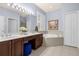 Bright primary bathroom featuring a vanity with double sinks, large mirror and a soaking tub at 4220 Cleary Way, Orlando, FL 32828