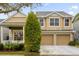 Two-story house with beige siding, three-car garage, and covered porch at 4220 Cleary Way, Orlando, FL 32828