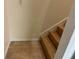 A wooden staircase features neutral walls and tile flooring at the base of the stairs at 4220 Cleary Way, Orlando, FL 32828