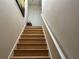 Interior view of wooden stairs with white railing leading to an upper level with a white door at 4220 Cleary Way, Orlando, FL 32828