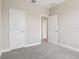 A cozy bedroom with neutral walls, carpeted floors, and two white doors, providing ample privacy at 5003 Railroad Vine Aly, Winter Garden, FL 34787