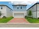 Charming two-story home with a blue and white exterior, brick driveway, and well-maintained lawn at 5003 Railroad Vine Aly, Winter Garden, FL 34787