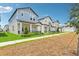 A street showcasing new two-story homes with inviting front porches and well-kept lawns in a modern community at 5003 Railroad Vine Aly, Winter Garden, FL 34787