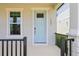 Charming light blue front door with modern hardware, complemented by a well-manicured porch and exterior at 5003 Railroad Vine Aly, Winter Garden, FL 34787