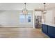 Open-concept kitchen and living space features stainless appliances and a striking navy blue kitchen island at 5003 Railroad Vine Aly, Winter Garden, FL 34787