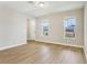 Spacious living room featuring attractive wood-look flooring, two large windows, and a welcoming entrance at 5003 Railroad Vine Aly, Winter Garden, FL 34787