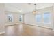 Large living area with wood-look floors, multiple windows for natural light, and modern light fixtures at 5003 Railroad Vine Aly, Winter Garden, FL 34787