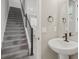 Bathroom featuring sleek fixtures, modern vanity and neutral color palette adjacent to the staircase at 5087 Railroad Vine Aly, Winter Garden, FL 34787