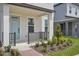 Inviting front porch with a blue door, contrasted with dark railings and manicured plants at 5087 Railroad Vine Aly, Winter Garden, FL 34787
