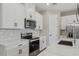 Modern kitchen with white cabinets, stone countertops, stainless steel appliances, and tiled backsplash at 5087 Railroad Vine Aly, Winter Garden, FL 34787