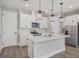 Beautiful kitchen featuring white cabinets, stainless appliances, and island with pendant lighting at 5087 Railroad Vine Aly, Winter Garden, FL 34787