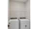 Practical laundry room with modern washer and dryer, and shelving for storage at 5087 Railroad Vine Aly, Winter Garden, FL 34787