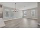 Spacious living room featuring wood floors, modern chandelier, and multiple windows for ample natural light at 5087 Railroad Vine Aly, Winter Garden, FL 34787