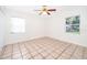 Bright bedroom with tile flooring, ceiling fan, and large window at 5416 Parkway Dr, Belle Isle, FL 32809