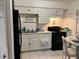 Bright kitchen with white cabinetry, black appliances, and tile flooring at 5885 Dahlia Dr # 24, Orlando, FL 32807