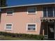 Light pink building exterior with multiple windows and entrance at 5885 Dahlia Dr # 31/116, Orlando, FL 32807