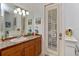 Bathroom features a mosaic countertop, white cabinetry, and natural light from the shuttered door at 6874 Valhalla Way, Windermere, FL 34786