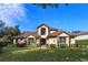 Two-story house with brown tile roof, landscaping, and a large front yard at 6874 Valhalla Way, Windermere, FL 34786