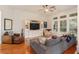 Cozy living room with a ceiling fan, hardwood floors, and built-in shelving surrounding the TV at 6874 Valhalla Way, Windermere, FL 34786