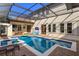 Enclosed pool area with a swimming pool, hot tub, outdoor bar, and brick paver deck at 6874 Valhalla Way, Windermere, FL 34786