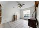 Bedroom with tiled floors, large window, and ceiling fan at 7025 Hiawassee Oak Dr, Orlando, FL 32818