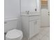 Bathroom featuring a white vanity, toilet, neutral tile, and shaker cabinets at 7895 Saint Giles Pl, Orlando, FL 32835
