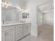 En-suite bathroom featuring dual vanity, modern lights, and access to bedroom at 7895 Saint Giles Pl, Orlando, FL 32835