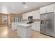 Spacious kitchen with stainless steel appliances, white cabinets, stone countertop island, and a lovely chandelier at 7895 Saint Giles Pl, Orlando, FL 32835