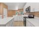 Modern kitchen featuring white cabinetry, stainless steel appliances, and a stone island countertop at 7895 Saint Giles Pl, Orlando, FL 32835