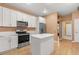 Updated kitchen boasts white cabinets, stainless steel appliances, and a stone island with breakfast bar at 7895 Saint Giles Pl, Orlando, FL 32835