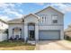 Charming two-story home with blue gray facade, arched windows, and an attached two-car garage at 7909 Chartreux Ln, Maitland, FL 32751