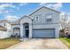 Inviting two-story home with a blue-grey exterior, two-car garage and well-manicured lawn at 7909 Chartreux Ln, Maitland, FL 32751