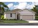 One-story home with light-colored siding, attached garage, and landscaping at 867 Pebble Crest Ln, Eagle Lake, FL 33839