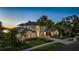 Luxury home at dusk with a long driveway and manicured landscaping at 9122 Bay Point Dr, Orlando, FL 32819