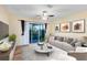 Relaxing living room featuring a comfy sofa, sliding glass doors, and a ceiling fan at 10329 Belfry Cir, Orlando, FL 32832