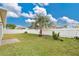 Backyard with grassy area, palm tree, and white fence at 1122 Hacienda Cir, Kissimmee, FL 34741